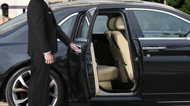 Chauffeur opening a luxury vehicle door